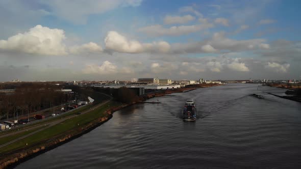 Fully loaded cargo barge sailing on the dutch river oude maas towards the next destination carrying alt