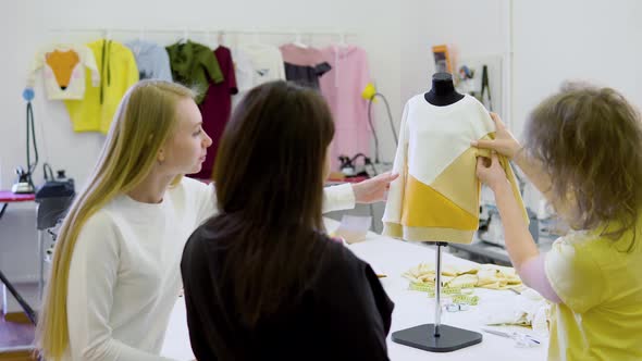 Shot of Three Fashion Designers Working and Deciding Details of New Collection of Clothes in the