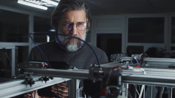 Mature Man Controlling 3D Printer alt