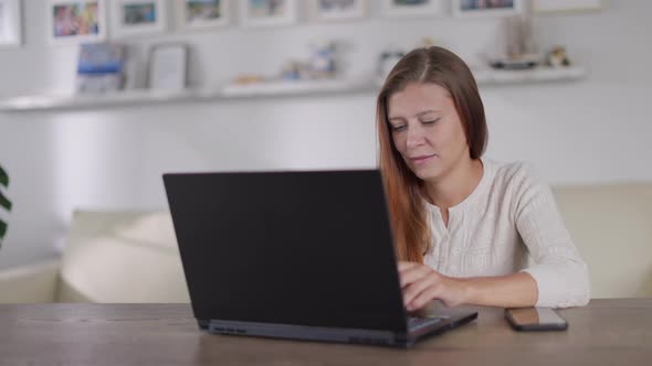 Beautiful Adult Woman With Red Hair Works Laptop At Home alt