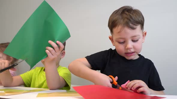 Brothers and Sisters Make Crafts From Colored Paper at Home