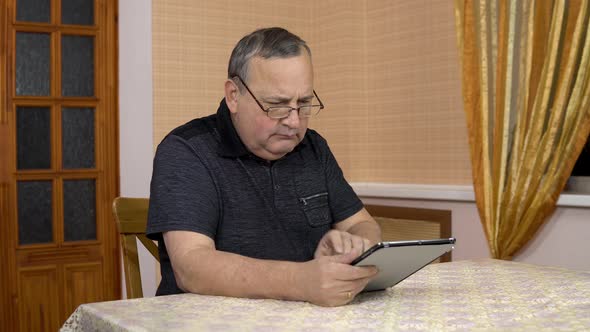 A Man Uses a Tablet for the First Time. The Old Man Does Not Understand How To Use the Tablet, Pokes alt