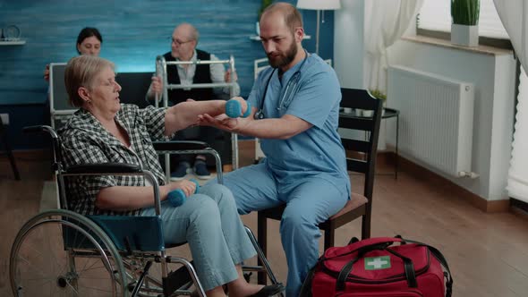 Medical Assistant Helping Disabled Woman with Physical Exercises alt