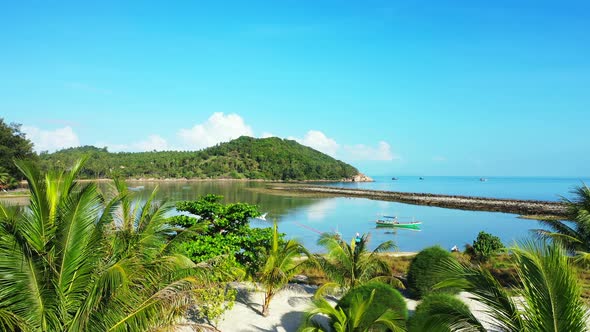 Peaceful vacations resort garden with palms and decorative trees on white sand washed by calm lagoon alt