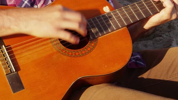 Close up of young person playing acoustic guitar alt