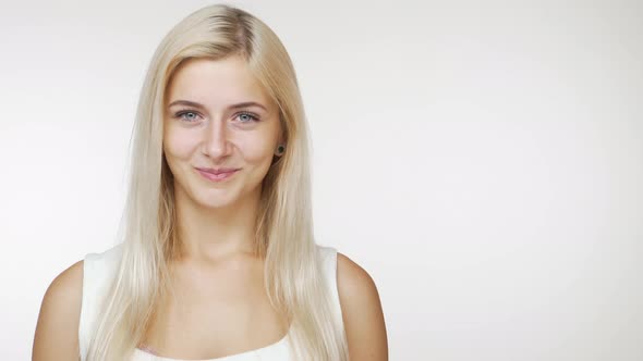 Beautiful Caucasian Female Blondie Smiling at Camera Flirting with Tricky Look Over White Background alt