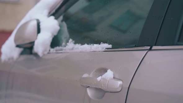 Snow Lies on Car with Folded Rearview Mirror and Front Door alt
