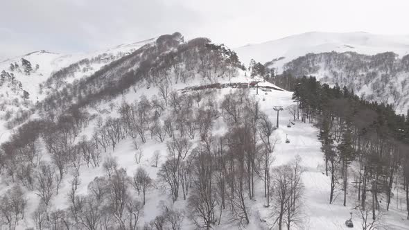 Flying over rope-way with gondolas at mountain resort Crystal Park in Bakuriani. Snowy winter day. alt