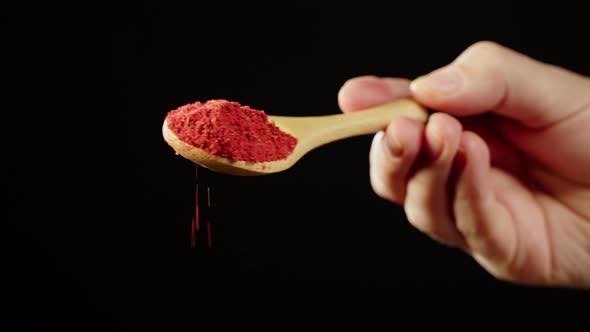 Pouring Paprika on Black Background Using Seasoning and Flavors alt