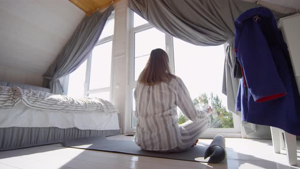 Woman in Pajama Meditating in Morning alt