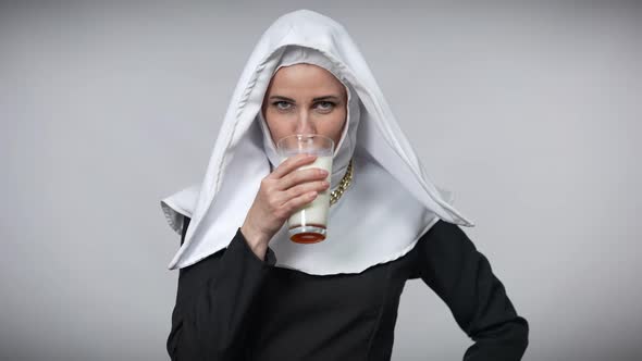 Smiling Woman in Nun Costume Drinking White Milk Licking Lips Smiling Looking at Camera alt