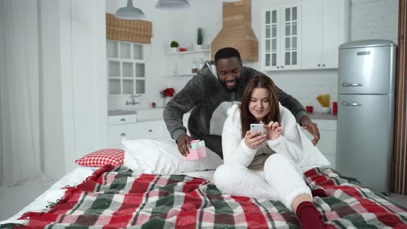 Loving Man Giving Gift to Happy Curvy Wife alt