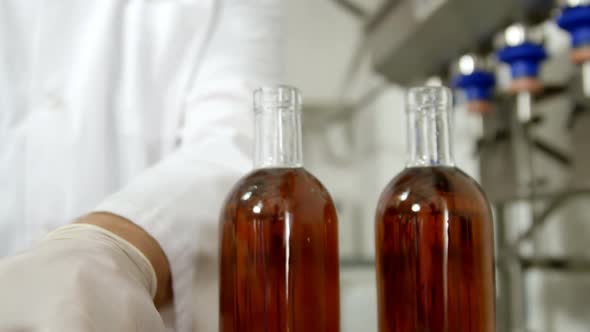 Male worker putting lid on liquor bottles 4k alt