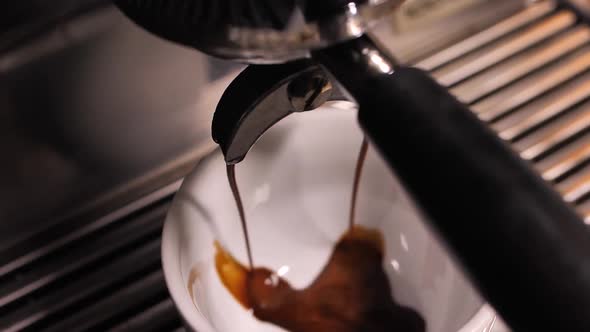 Making espresso in professional coffee machine high angle close up shot alt