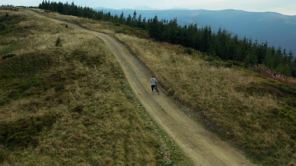 Man with Bike Mountain View Doing Active Sport Hilly Road Woods Background alt
