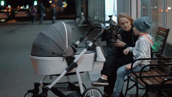 Woman with baby and elder son spending evening outside alt