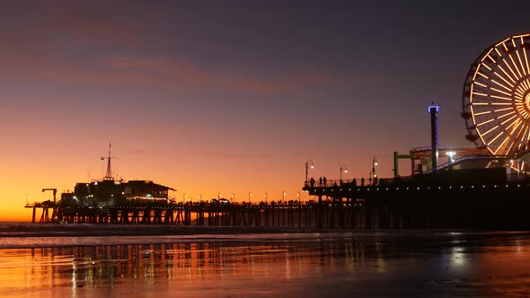 Twilight Waves Against Classic Illuminated Ferris Wheel, Amusement Park on Pier in Santa Monica alt