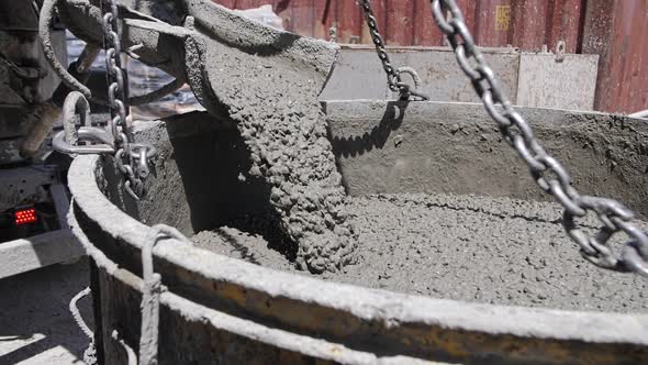 concrete is poured from a concrete mixer