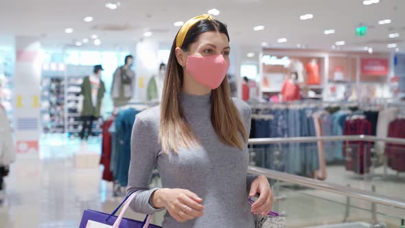 Pretty Lady in Expectation Wearing Face Mask During Shopping alt