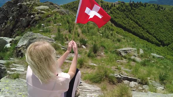 Woman with Swiss Flag on Cardada Mount alt