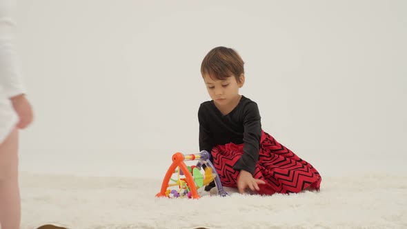 Toddler Girl Wearing Diaper and Her Sister Playing with Balls alt