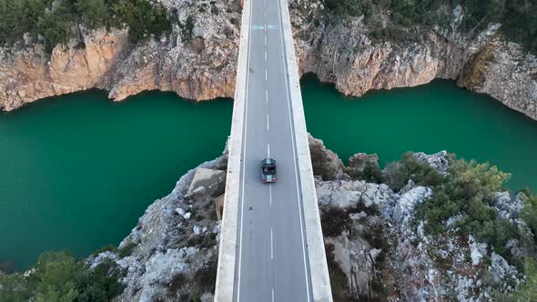 A car passes through a bridge over a river aerial view 4 K alt