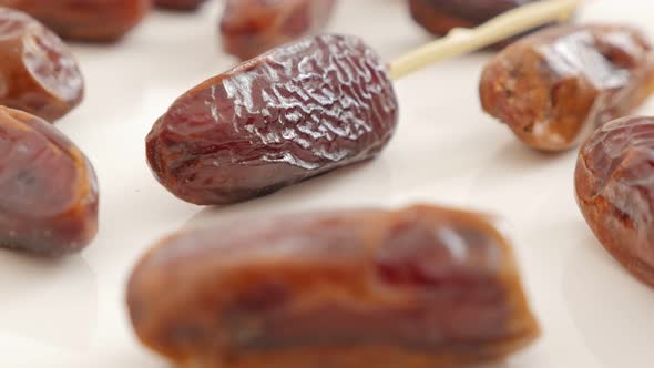 Palm dates  exotic eastern fruit on white background slow tilting   4K 2160p UltraHD footage - Tasty alt