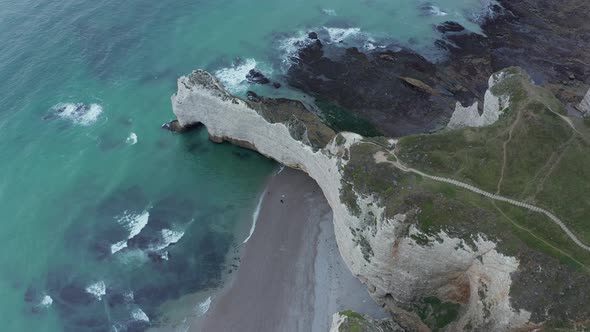 Wide Establishing Shot of Cliff Shoreline and Ruff Ocean Waves, Etretat Cliffs in France alt