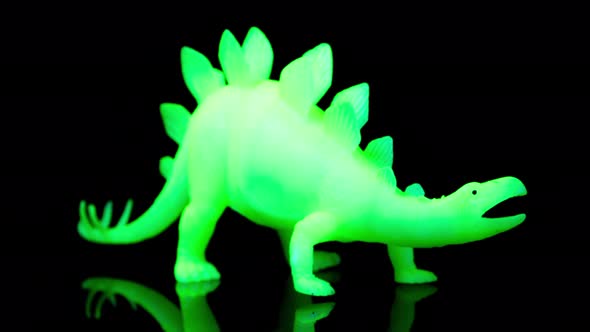 Green Toy Dinosaur Turning Agaisnt Black alt