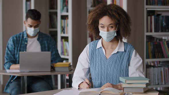 Students Study in Library Young Woman in Protective Mask Writing Notes Does Homework Showing Gesture alt