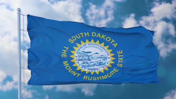 South Dakota Flag on a Flagpole Waving in the Wind Blue Sky Background alt