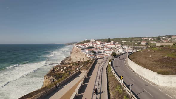 People walking on walkway along seaside cliff, coastal road near Azenhas do Mar, Portugal alt