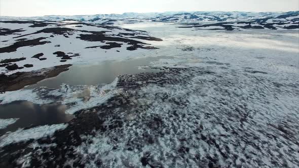 Frozen lake in Norway viewed from air, aerial view.