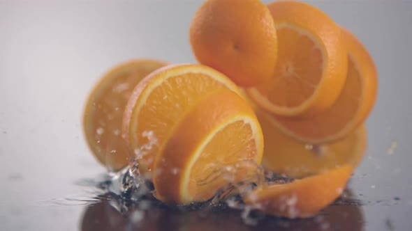 Fresh orange slices in circle shape fall down in slow motion