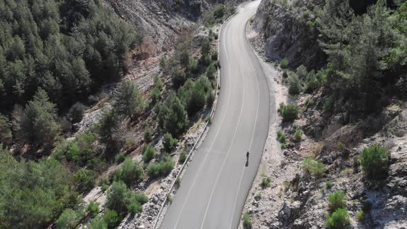 Cyclist is cycling on empty road alt