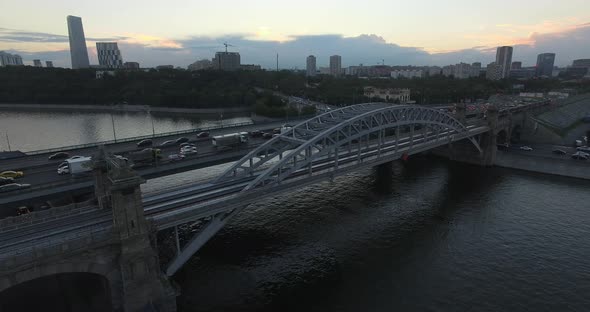 An Aerial View of a Railway Bridge Over the River Against the Evening Urban View alt