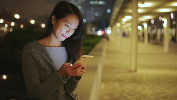 Woman using cellphone at night alt
