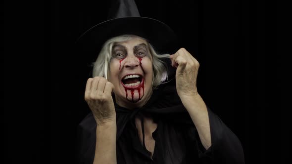 Old Witch Halloween Makeup. Elderly Woman Portrait with Blood on Her Face alt