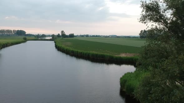 Rural landscape river and closeby flying near natural trees, aerial drone view alt