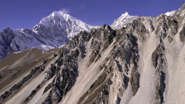 Flying along the mountains in Nepal looking at snow capped Kyanjin Ri alt
