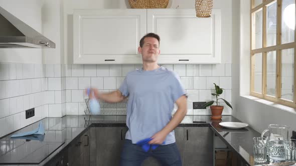 Happy Housekeeper Enjoys the Cleaning Process Dancing in Kitchen with Detergents in Her Hands