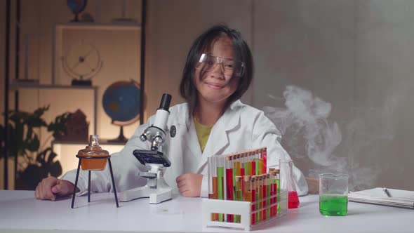 Young Scientist Girl With Dirty Face Looking At Microscope And Smiles To Camera In Laboratory alt