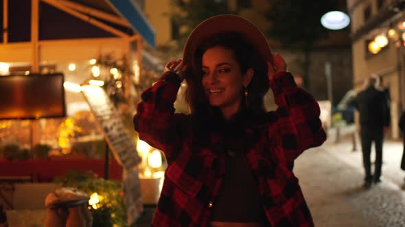 Girl with a Hat Having Fun on the Evening Street