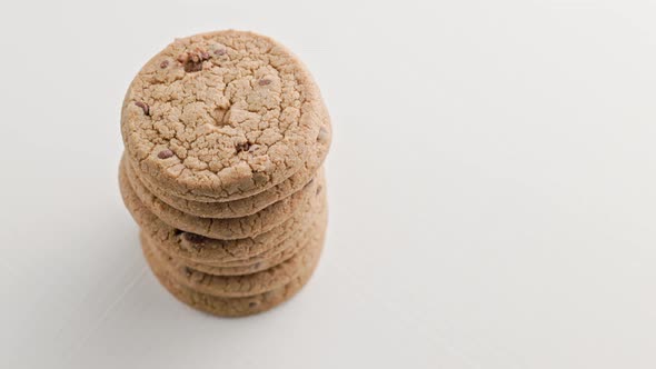 Vertical Stack of Round Chip Cake Cookies with Chocolate on White Surface Slow Rotating Looped