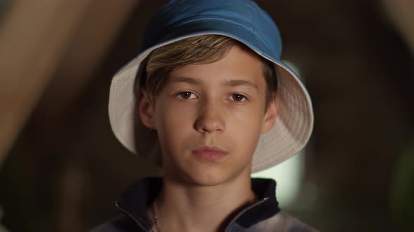 Portrait of a Sad Serious Boy in Hat Looking at the Camera Indoors Camera Moves Away