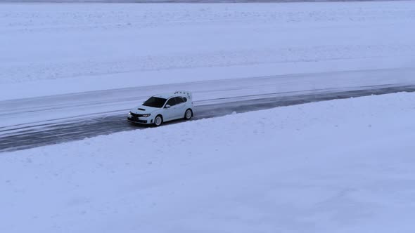 Aerial view of the rally car on a snowy road alt