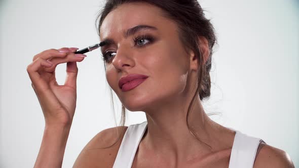 Eyebrows Makeup. Woman Combing Eyebrow With Brush Closeup alt