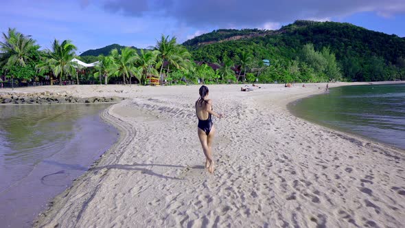 Pretty Asian Woman in Black Swimsuit Running Alone on a Sandbar Thailand