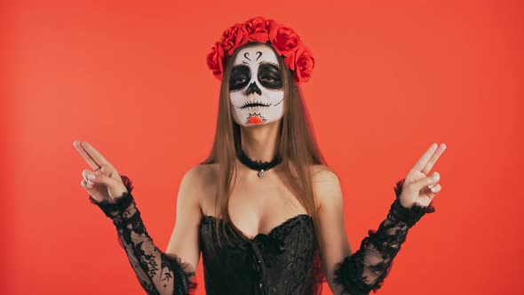 Day of Dead Female with Skull Makeup Taking Imaginary Pistols Out of Holster Smiling and Posing with alt