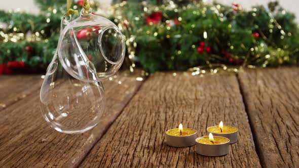 Tealight candles with hanging glass lamps on a plank alt